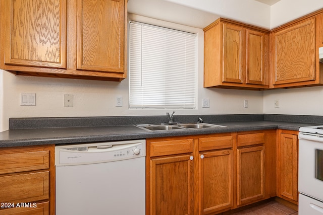 kitchen featuring white appliances, tile patterned floors, and sink