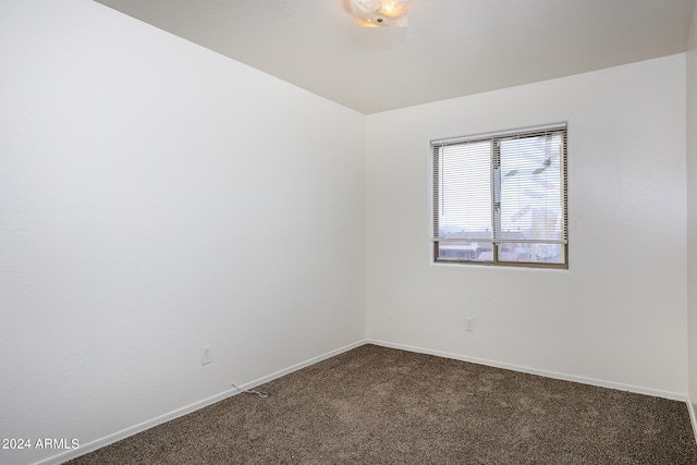 unfurnished room featuring dark carpet