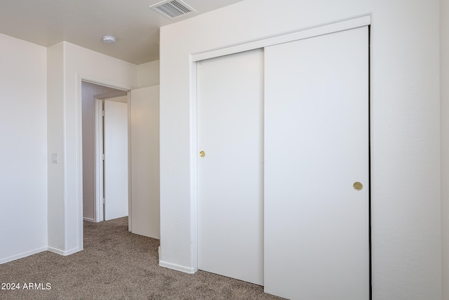 unfurnished bedroom with a closet and carpet flooring