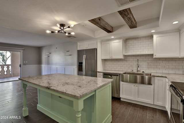 kitchen with white cabinets, a kitchen island, stainless steel appliances, and dark wood-type flooring