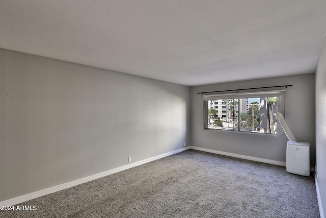 carpeted spare room featuring a textured ceiling