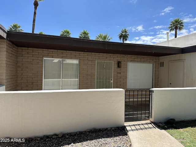 220 S Old Litchfield Rd Unit 104, Litchfield Park, AZ 85340 - doorway to property featuring a gate and brick siding
