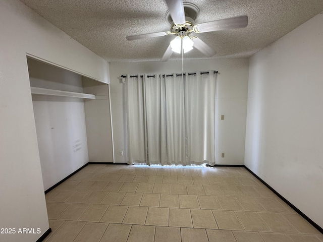 220 S Old Litchfield Rd Unit 104, Litchfield Park, AZ 85340 - unfurnished bedroom featuring a textured ceiling, ceiling fan, a closet, and baseboards