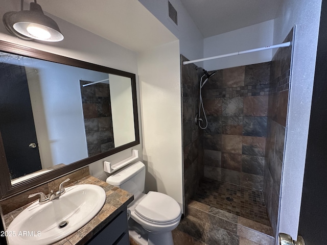 220 S Old Litchfield Rd Unit 104, Litchfield Park, AZ 85340 - bathroom featuring toilet, vanity, tiled shower, and stone finish flooring