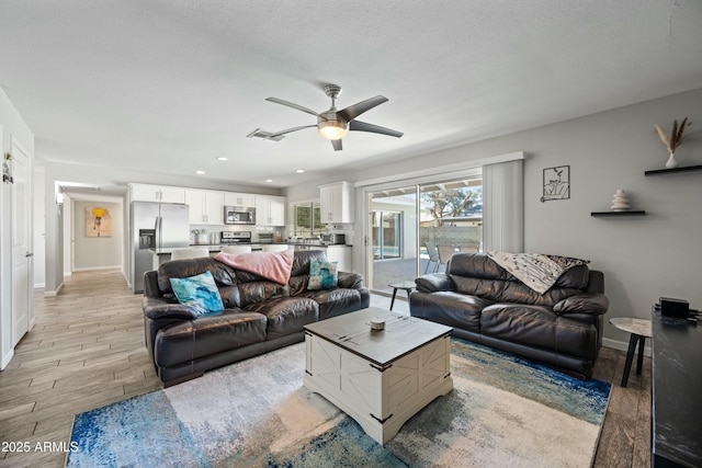 living room featuring a textured ceiling and ceiling fan