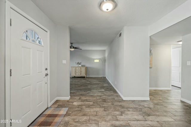 entryway with a textured ceiling and ceiling fan