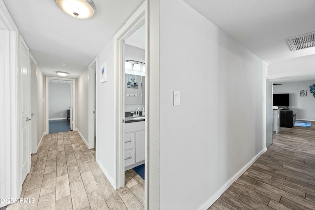 hallway featuring sink and hardwood / wood-style floors