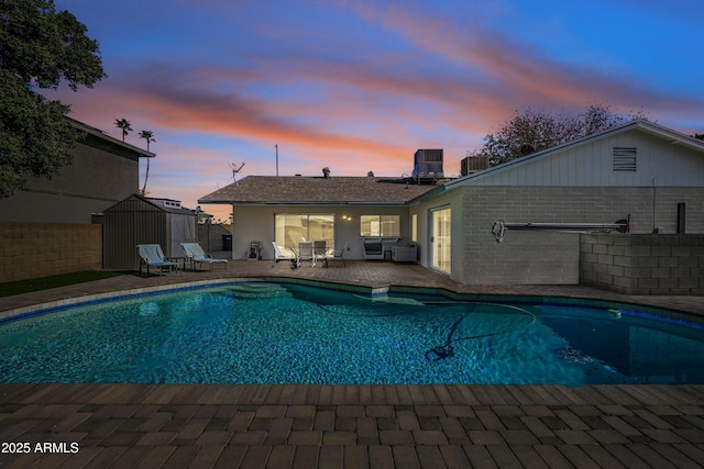 pool at dusk with a patio