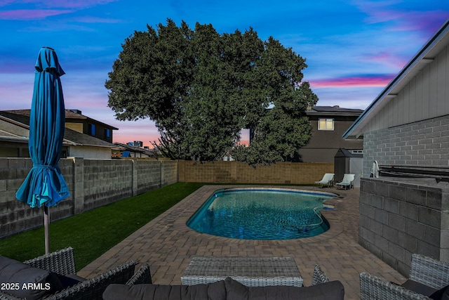 pool at dusk featuring a patio area