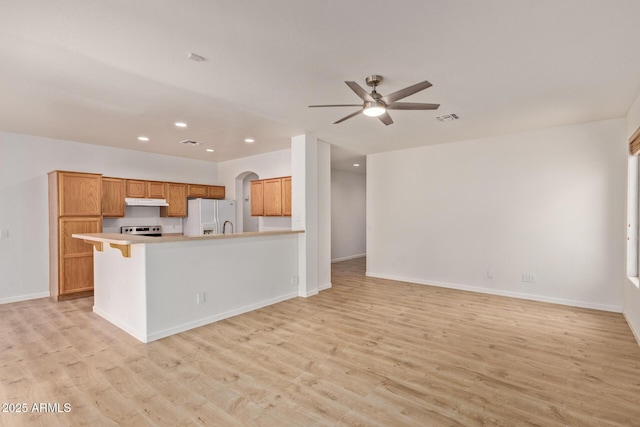 2590 S Buckaroo Trl, Gilbert, AZ 85295 - kitchen featuring white refrigerator with ice dispenser, under cabinet range hood, light wood-type flooring, open floor plan, and recessed lighting