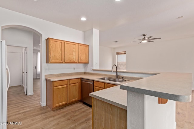 2590 S Buckaroo Trl, Gilbert, AZ 85295 - kitchen with stainless steel dishwasher, a sink, a peninsula, freestanding refrigerator, and light wood-style flooring