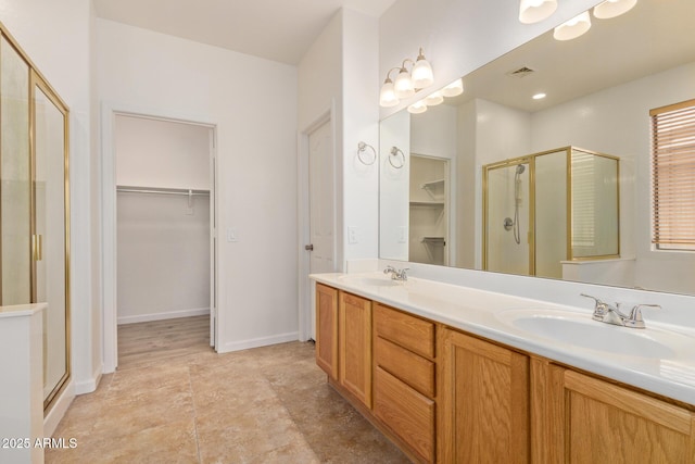 2590 S Buckaroo Trl, Gilbert, AZ 85295 - bathroom featuring a stall shower, a walk in closet, and double vanity