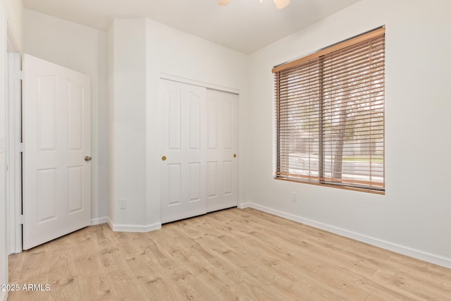 2590 S Buckaroo Trl, Gilbert, AZ 85295 - unfurnished bedroom featuring baseboards, light wood finished floors, and a closet