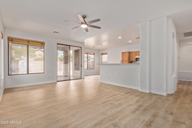 2590 S Buckaroo Trl, Gilbert, AZ 85295 - unfurnished living room with a ceiling fan, recessed lighting, baseboards, and light wood finished floors