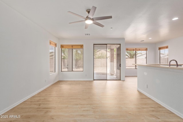 2590 S Buckaroo Trl, Gilbert, AZ 85295 - unfurnished living room featuring ceiling fan, baseboards, light wood-type flooring, and recessed lighting