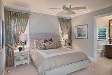 bedroom featuring ceiling fan, ensuite bath, and crown molding