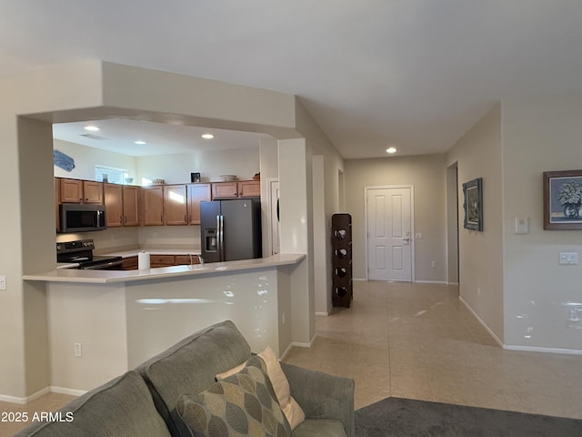 kitchen with light tile patterned flooring, kitchen peninsula, and appliances with stainless steel finishes