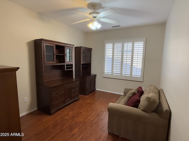 sitting room with dark wood-type flooring and ceiling fan