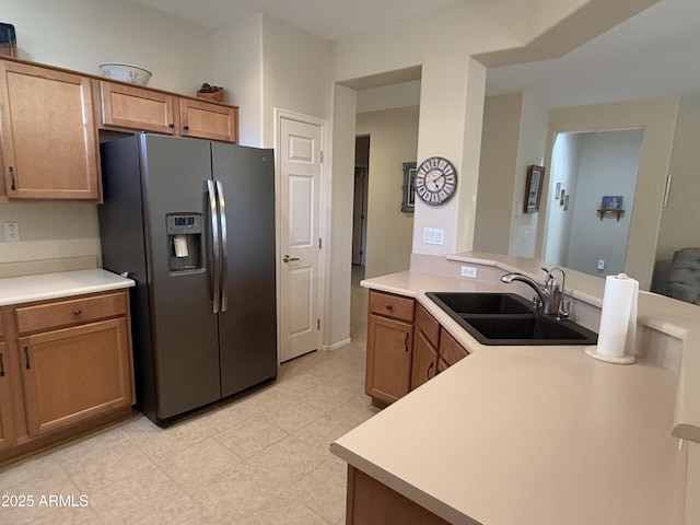 kitchen with stainless steel fridge, kitchen peninsula, and sink