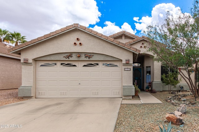 view of front facade featuring driveway, a tiled roof, an attached garage, and stucco siding