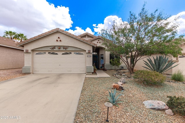 view of front facade with a garage, a tile roof, concrete driveway, and stucco siding