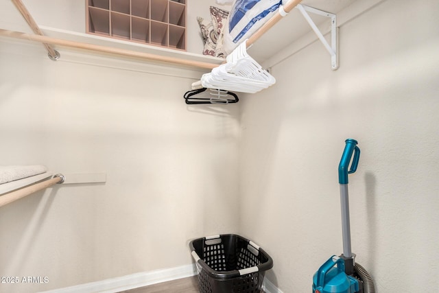 walk in closet with wood finished floors