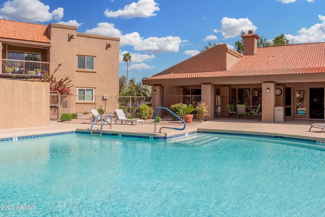 community pool featuring fence and a patio area