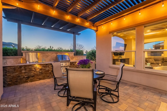 view of patio with exterior kitchen, outdoor dining area, a pergola, and a grill