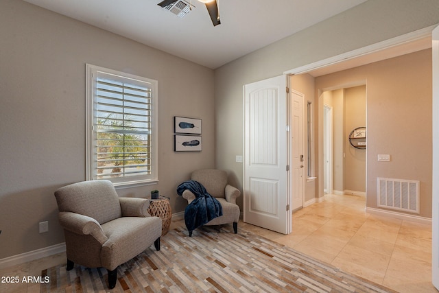 sitting room with baseboards, visible vents, and ceiling fan