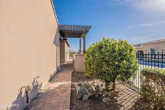 view of side of home with stucco siding and fence