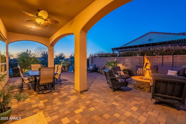 view of patio / terrace with ceiling fan, a fire pit, outdoor dining area, and a fenced backyard