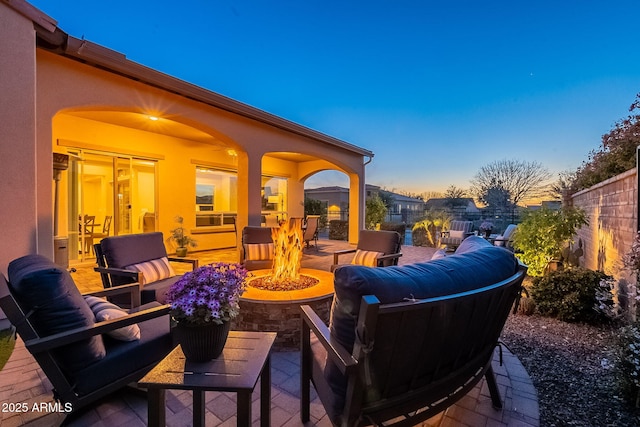 view of patio featuring an outdoor living space with a fire pit and fence