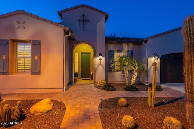 mediterranean / spanish-style house with an attached garage and stucco siding