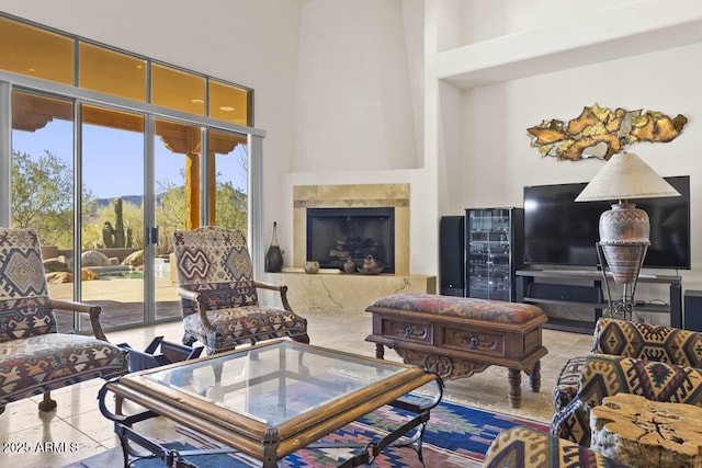 living area featuring a high end fireplace, wine cooler, and a high ceiling