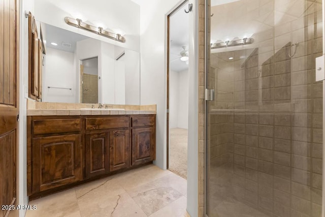 bathroom featuring visible vents, vanity, ceiling fan, and a shower stall