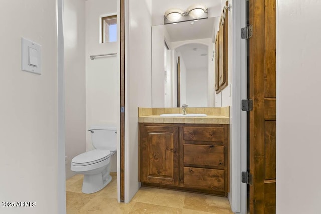 bathroom featuring tile patterned flooring, toilet, and vanity