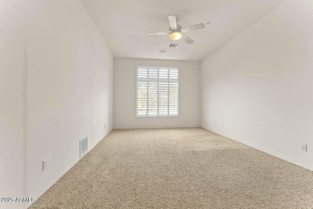 spare room featuring visible vents, carpet, and ceiling fan