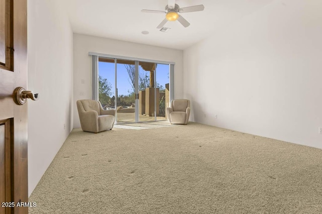 unfurnished room with visible vents, a ceiling fan, and carpet flooring