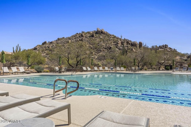 pool with a mountain view, a patio, and fence