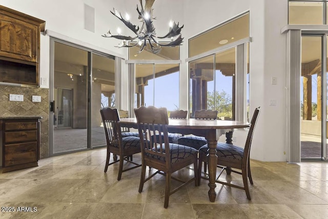 dining room with a high ceiling, visible vents, and a chandelier