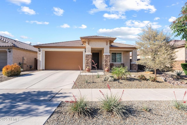 prairie-style home featuring a tile roof, stone siding, concrete driveway, an attached garage, and stucco siding