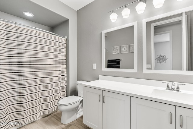 full bath featuring toilet, vanity, and wood finished floors
