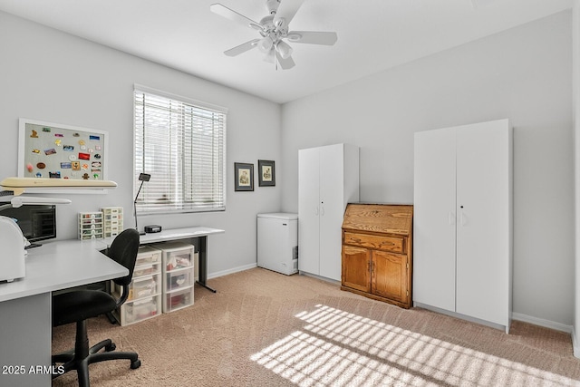 office area with baseboards, a ceiling fan, and light colored carpet