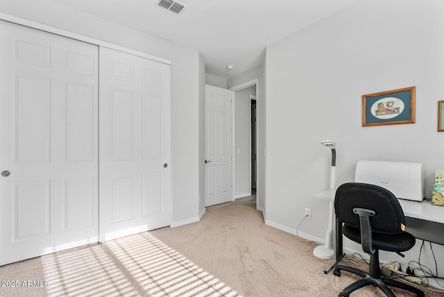 office area featuring baseboards, visible vents, and light carpet