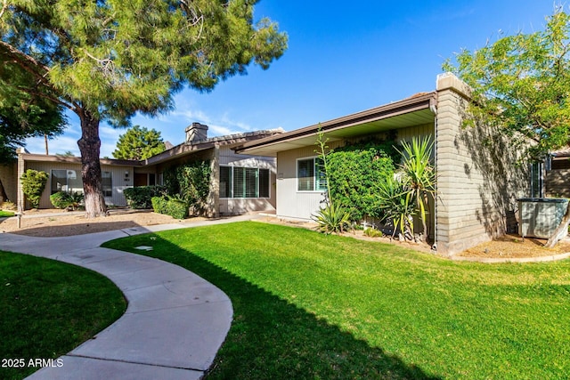 rear view of property with a lawn