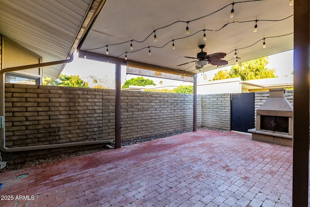 view of patio / terrace featuring ceiling fan and an outdoor fireplace