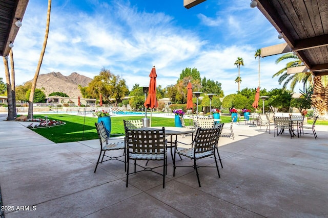 view of patio with a mountain view and a community pool