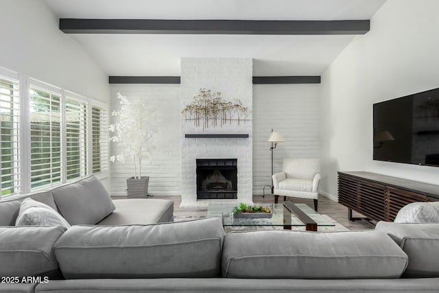 living room with vaulted ceiling with beams, hardwood / wood-style flooring, and a fireplace