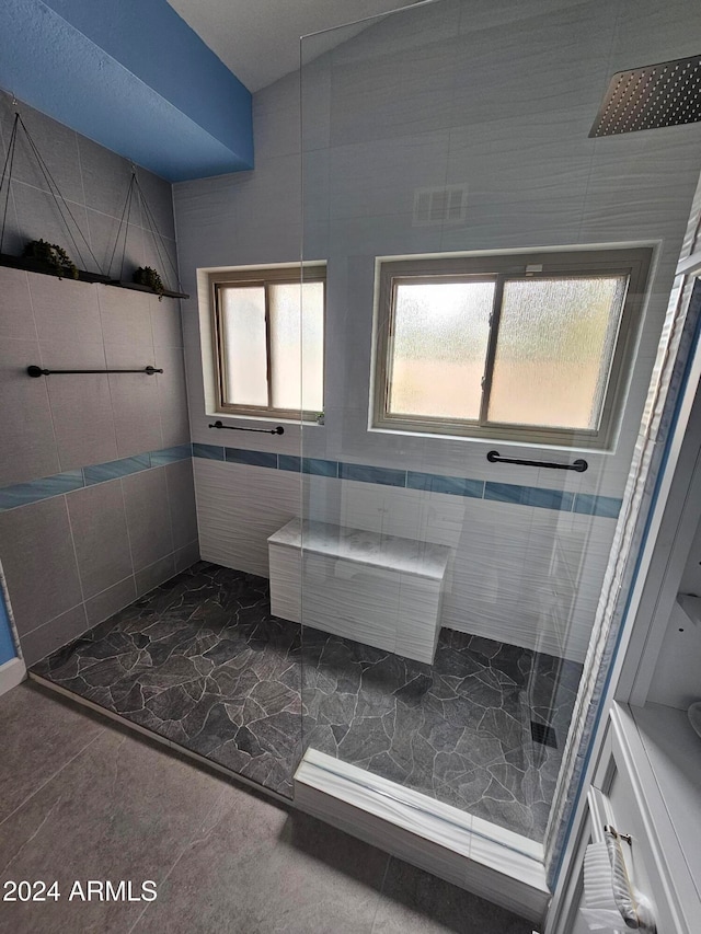 bathroom featuring a shower and tile walls