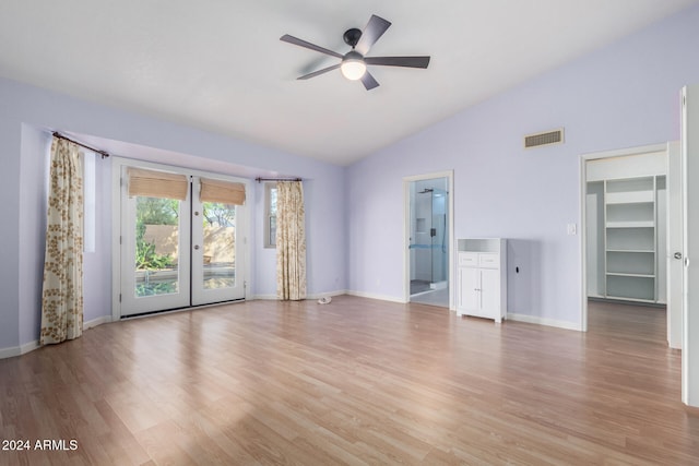 unfurnished living room with ceiling fan, light wood-type flooring, and vaulted ceiling